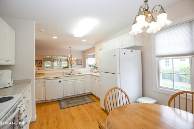 kitchen with white appliances, sink, hanging light fixtures, and white cabinetry