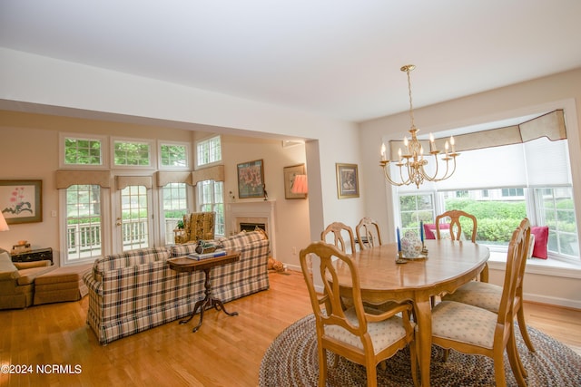 dining room with light wood-type flooring and a notable chandelier