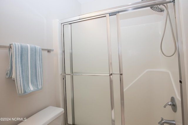 bathroom with an enclosed shower and toilet