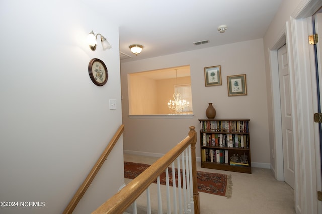 corridor with an inviting chandelier and carpet