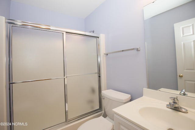 full bathroom with enclosed tub / shower combo, vanity, and toilet