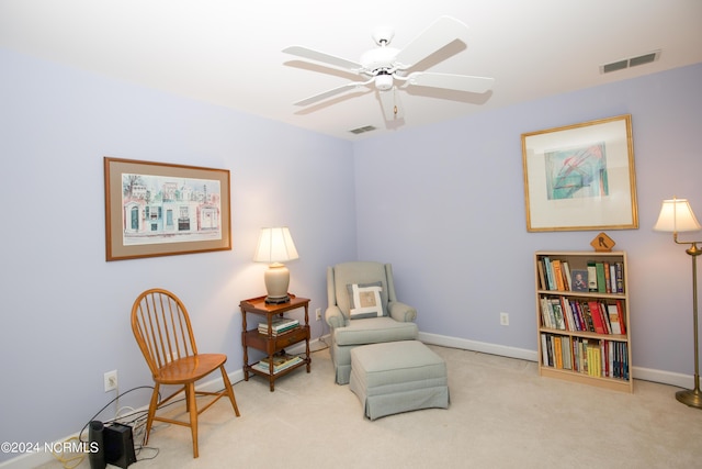 living area with ceiling fan and light carpet