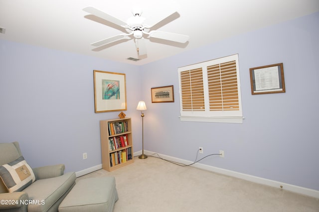 living area with light colored carpet and ceiling fan