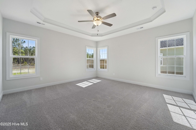 carpeted empty room with a raised ceiling, ornamental molding, and ceiling fan