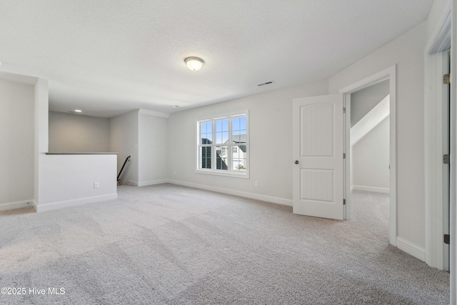 unfurnished room featuring light carpet and a textured ceiling