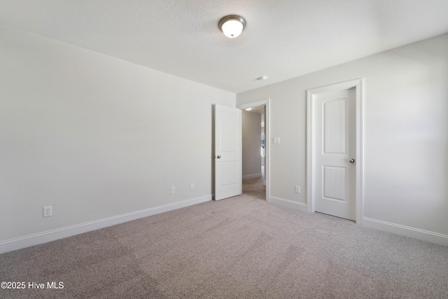 empty room featuring light colored carpet and a textured ceiling