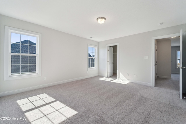 unfurnished bedroom featuring a walk in closet and light carpet