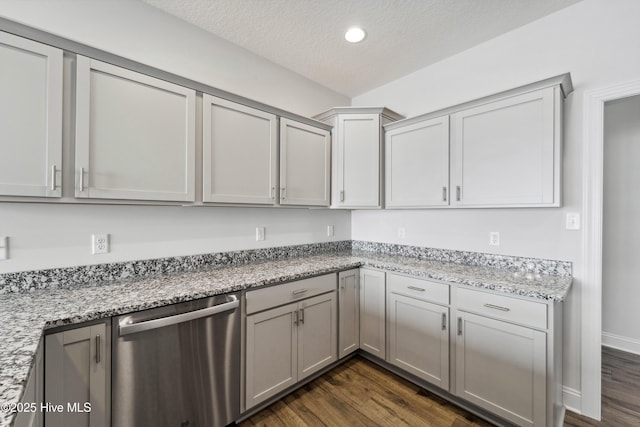 kitchen featuring stainless steel dishwasher, light stone counters, and dark hardwood / wood-style flooring