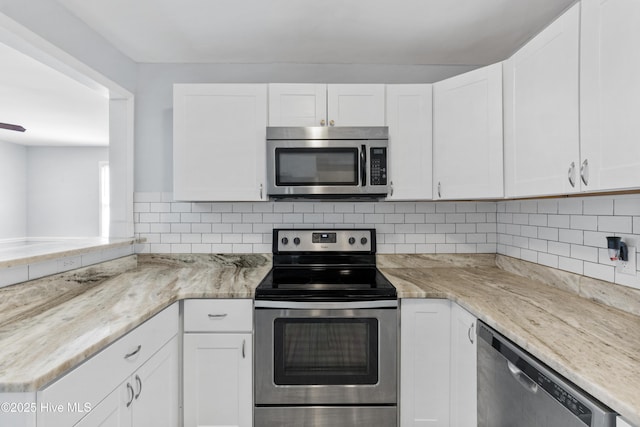 kitchen featuring stainless steel appliances, white cabinetry, and tasteful backsplash