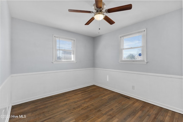 empty room featuring dark wood-type flooring and ceiling fan