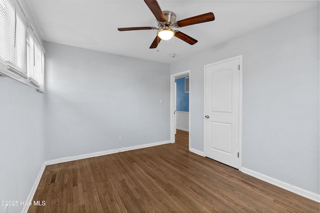 empty room with ceiling fan and dark hardwood / wood-style flooring