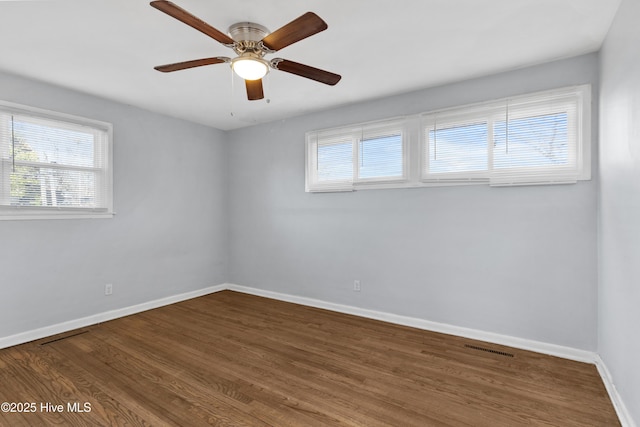 spare room featuring ceiling fan, a wealth of natural light, and hardwood / wood-style floors