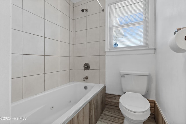 bathroom with toilet and tiled shower / bath