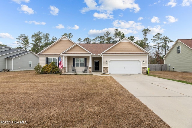 view of front of house featuring a porch, a garage, and a front lawn