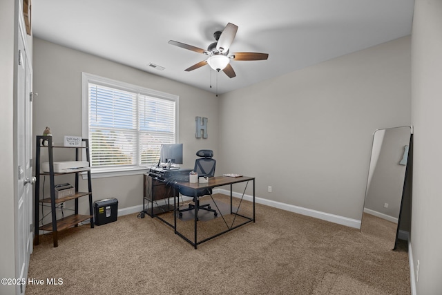 carpeted home office featuring ceiling fan