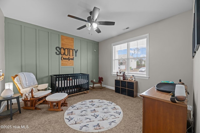 bedroom with carpet flooring, ceiling fan, and a nursery area