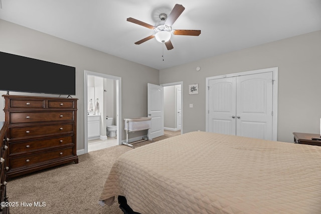 carpeted bedroom with ceiling fan, ensuite bath, and a closet