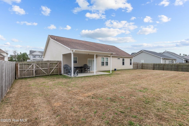 rear view of property featuring a lawn and a patio