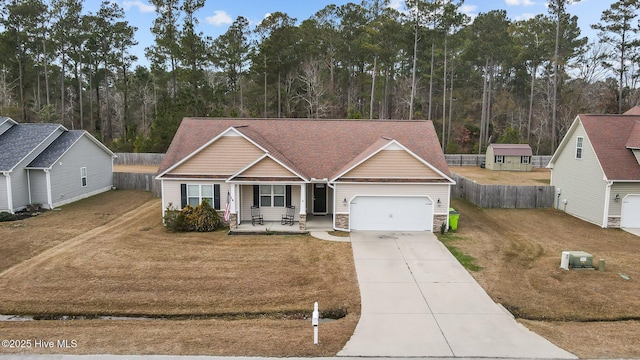 view of front facade featuring a garage, central AC unit, a porch, and a front yard