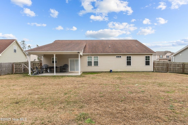 rear view of property with a yard and a patio