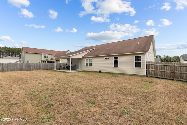 rear view of property with a yard and a patio