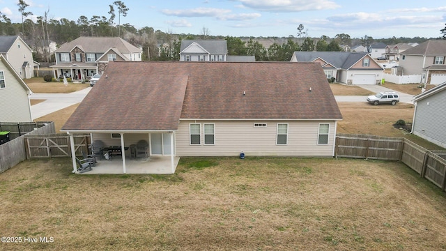 rear view of property featuring a lawn and a patio