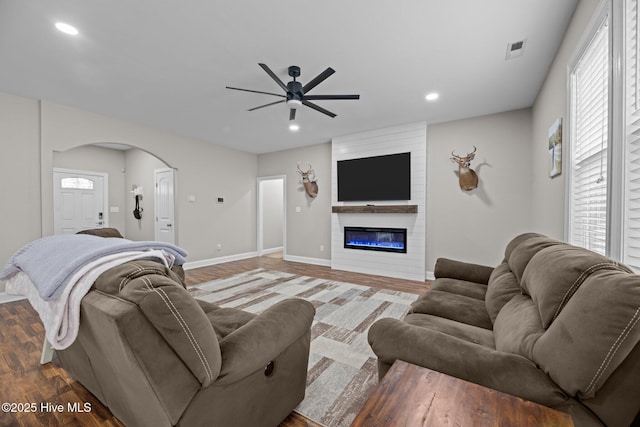 living room with ceiling fan, a fireplace, and hardwood / wood-style flooring