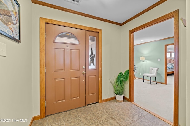 foyer entrance featuring crown molding and light colored carpet