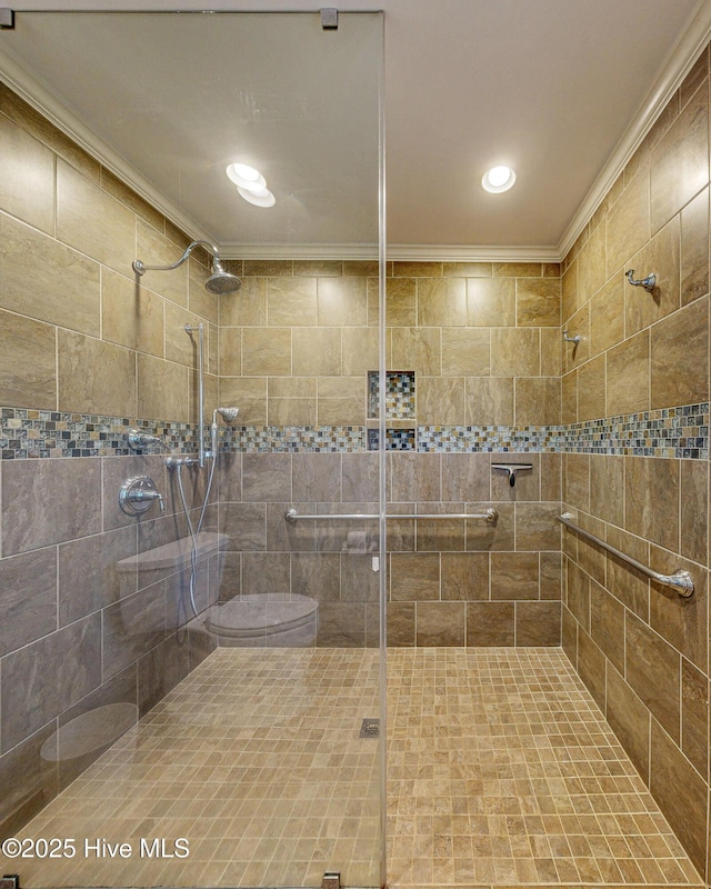 bathroom with ornamental molding and a tile shower