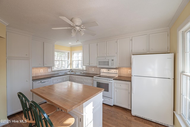 kitchen featuring white cabinetry, white appliances, dark hardwood / wood-style floors, and decorative backsplash