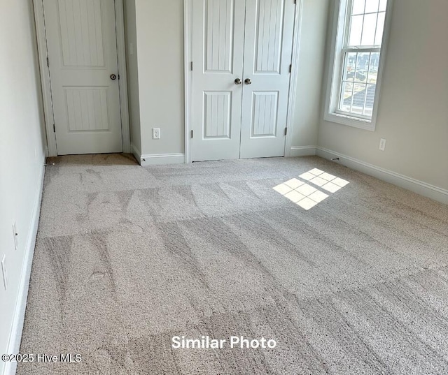 unfurnished bedroom featuring a closet and light colored carpet