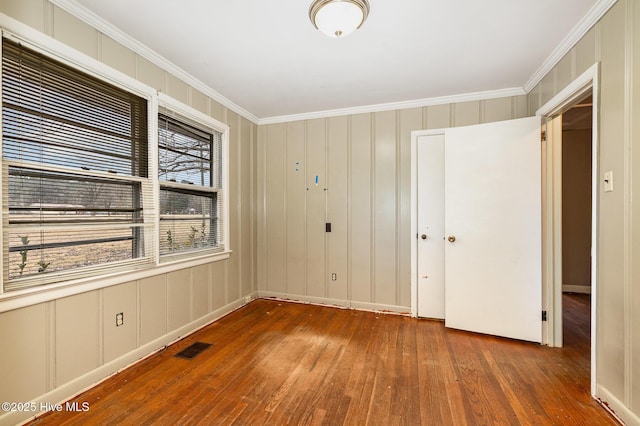 empty room featuring dark hardwood / wood-style flooring and ornamental molding