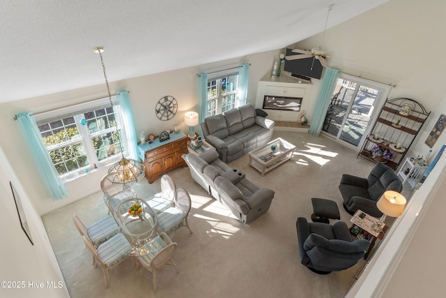 living room featuring carpet flooring, vaulted ceiling, and ceiling fan