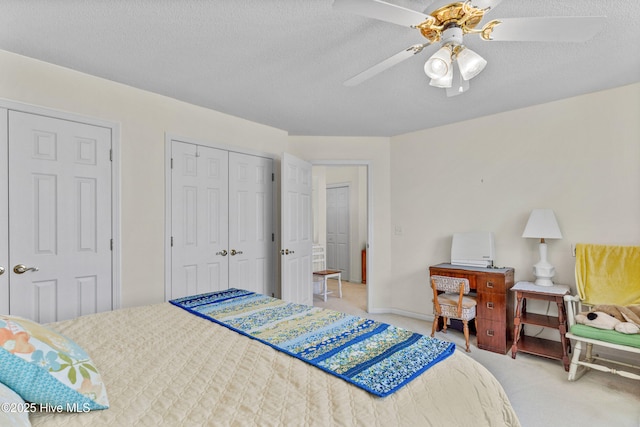 bedroom with a closet, light carpet, ceiling fan, and a textured ceiling