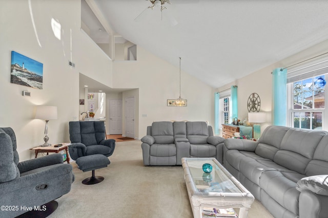 living room featuring high vaulted ceiling, visible vents, and light colored carpet