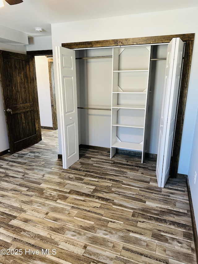 unfurnished bedroom with dark hardwood / wood-style flooring and a closet