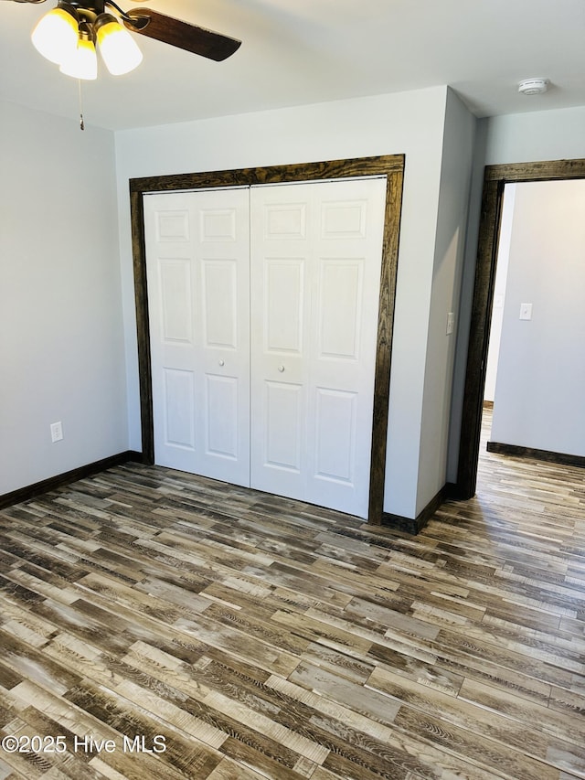 unfurnished bedroom with ceiling fan, dark hardwood / wood-style flooring, and a closet