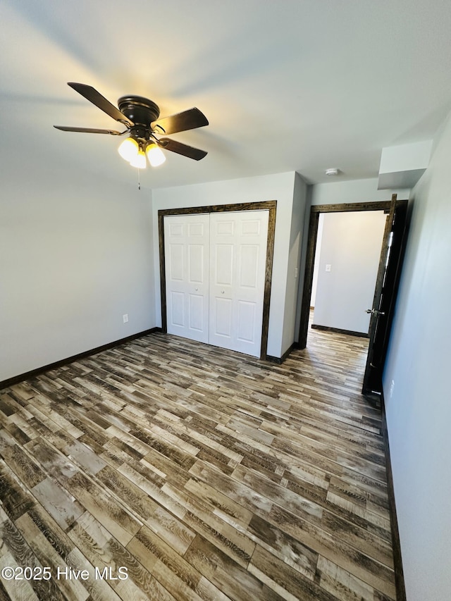 unfurnished bedroom featuring ceiling fan, wood-type flooring, and a closet