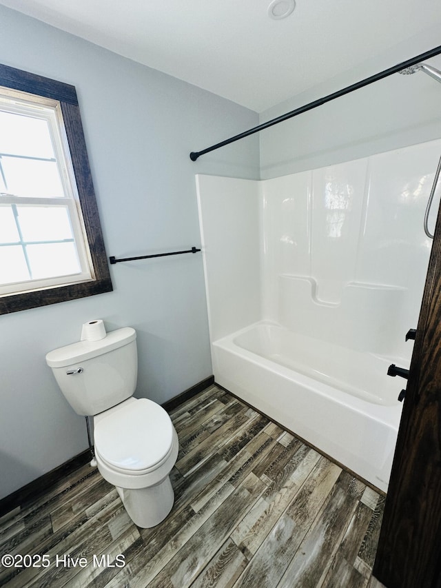 bathroom with shower / bath combination, toilet, and wood-type flooring