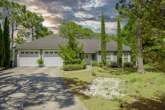 ranch-style house featuring a yard and a garage