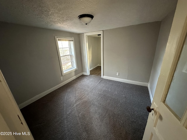 unfurnished room featuring carpet and a textured ceiling