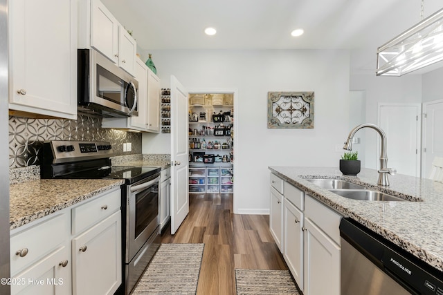 kitchen featuring sink, stainless steel appliances, white cabinetry, and hardwood / wood-style flooring