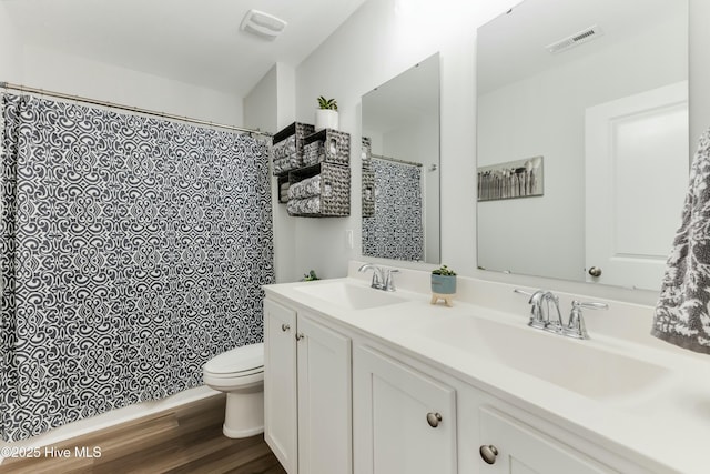 bathroom with toilet, vanity, and hardwood / wood-style flooring