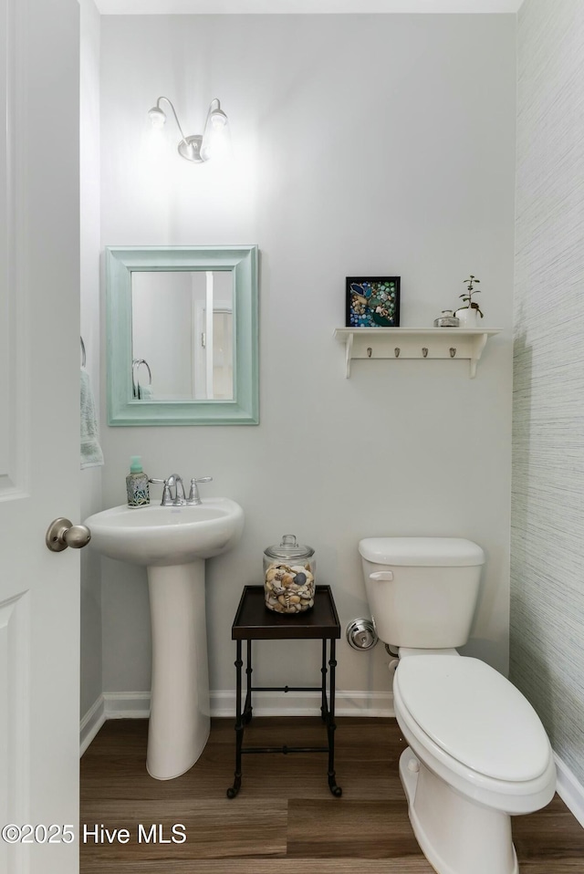 bathroom featuring toilet, wood-type flooring, and sink