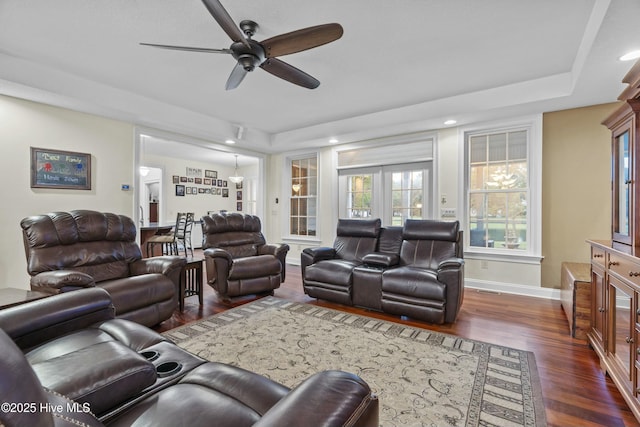 living room featuring a tray ceiling, dark hardwood / wood-style floors, ceiling fan, and french doors