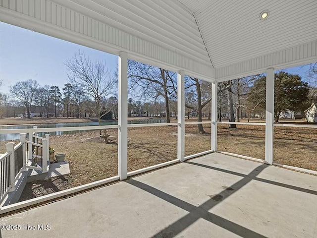 unfurnished sunroom featuring a water view and vaulted ceiling