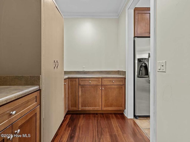 kitchen featuring stainless steel fridge with ice dispenser, dark wood-type flooring, and ornamental molding