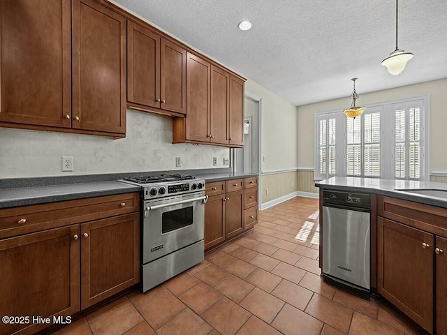 kitchen with tile patterned floors, decorative light fixtures, gas stove, and a textured ceiling