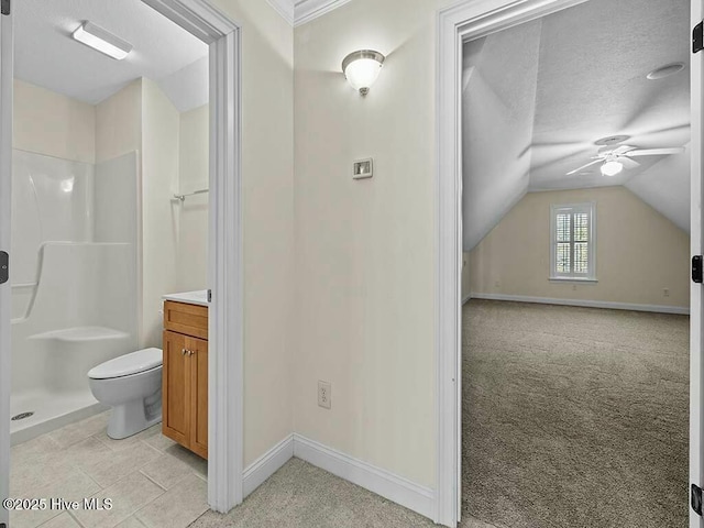 bathroom featuring vaulted ceiling, a shower, vanity, ceiling fan, and toilet