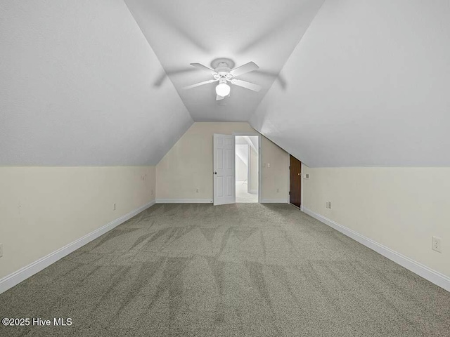 additional living space featuring vaulted ceiling, light colored carpet, and ceiling fan